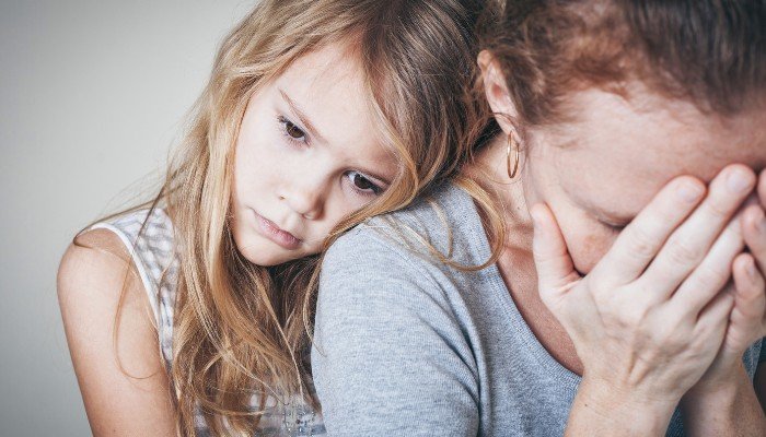 Sad Mother with Daughter Leaning on Her Shoulder